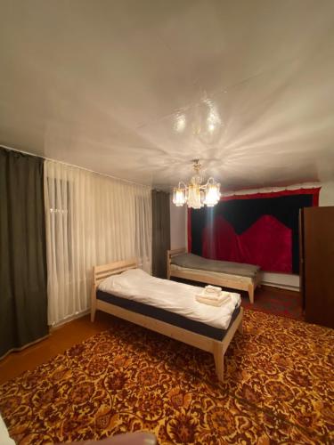 a bedroom with a bed and a chandelier at Nooruz hotel in Naryn