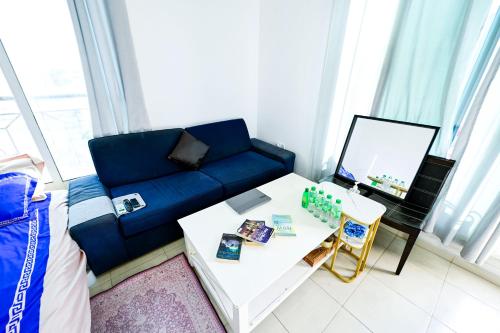 a living room with a blue couch and a table at Studio - Private - Abu Dhabi in Abu Dhabi