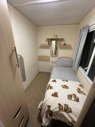 a small room with a bed and a window at Croft View Caravan Holidays in Dunvegan