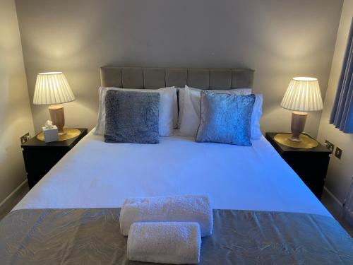 a bedroom with a large white bed with blue pillows at Starlight Cottage Peaceful Spiritual Room near Glastonbury Tor & Chalice Well in Glastonbury