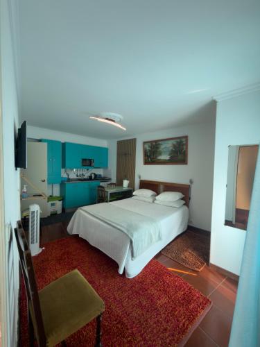 a bedroom with a white bed and a red rug at Anchor House in Câmara de Lobos