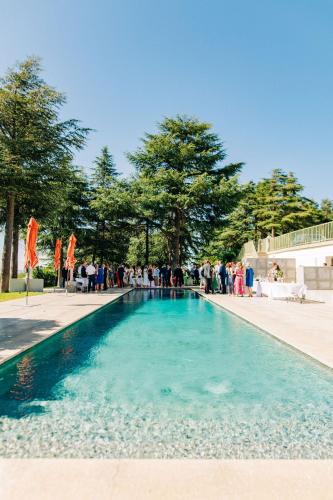 a large swimming pool with people standing around it at Château de Valmy - Chambres d'hôtes in Argelès-sur-Mer