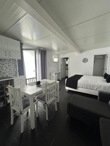 a bedroom with a bed and a table and chairs at The Rock Guest House in Ponta Delgada
