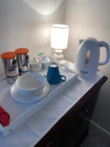 a shelf with a tea pot and cups and a lamp at Starlight Cottage Peaceful Spiritual Room near Glastonbury Tor & Chalice Well in Glastonbury