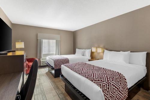 a hotel room with two beds and a television at Best Western Colonel Butler Inn in Niagara-on-the-Lake