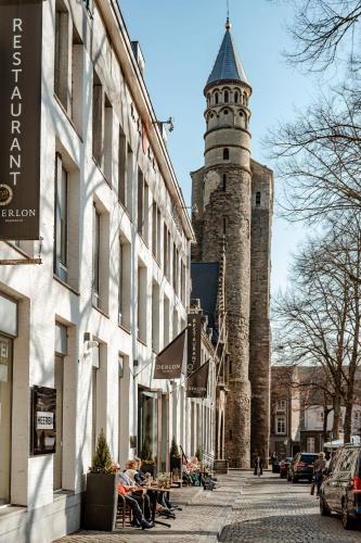 a building with a clock tower on a street at Hotel Derlon in Maastricht