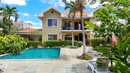 eine Villa mit Swimmingpool vor einem Haus in der Unterkunft Hotel Robledal in Alajuela