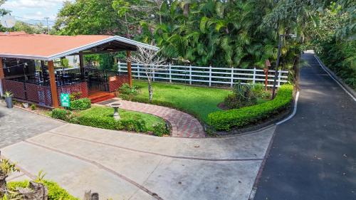 Draufsicht auf ein Haus mit weißem Zaun in der Unterkunft Hotel Robledal in Alajuela