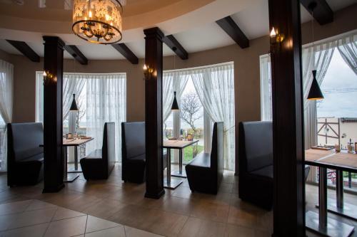 een eetkamer met tafels, stoelen en ramen bij Hotel Zolotaya Milya in Zelenogradsk