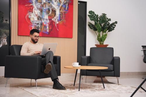 a man sitting in a chair with a laptop at Hotel Regency Boutique La Feria in Bogotá