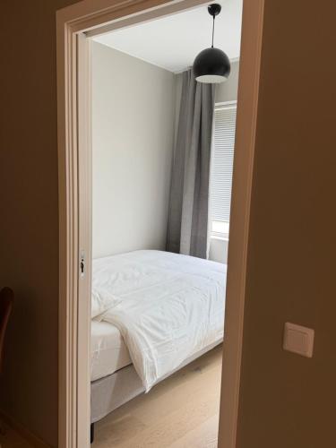 a bedroom with a white bed and a window at Oslo Gateway Apartment in Lørenskog in Lorenskog