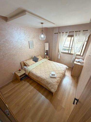 a bedroom with a large bed and a window at Vivienda 01 Appartement moderne au cœur de Mohammedia , Calme et Confort in Mohammedia
