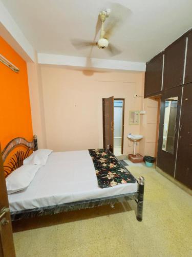 a bedroom with a bed with a ceiling fan at Delight rooms in Mysore
