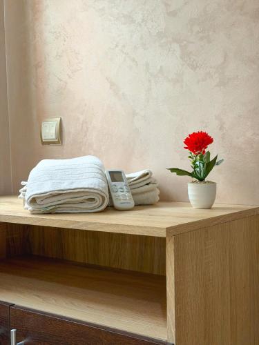 a table with a cell phone and a flower on it at Vivienda 01 Appartement moderne au cœur de Mohammedia , Calme et Confort in Mohammedia