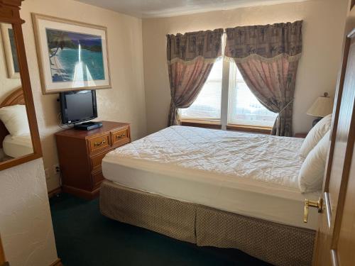 a bedroom with a bed and a television and a window at Sierra Suites in Daytona Beach