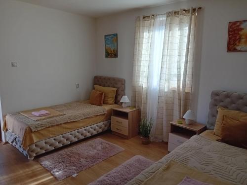 a bedroom with two twin beds and a window at Zlatna Vila 2 in Kanjiža