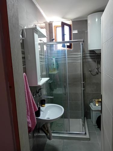 a bathroom with a glass shower and a sink at Zlatna Vila 2 in Kanjiža