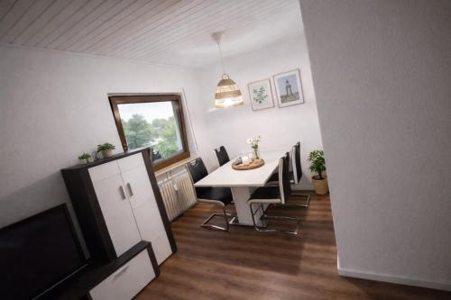 a dining room with a table and chairs and a tv at Appartment Okarben in Karben