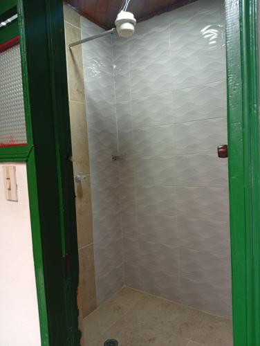 a shower with a glass door in a bathroom at Posada La Casona in El Cocuy