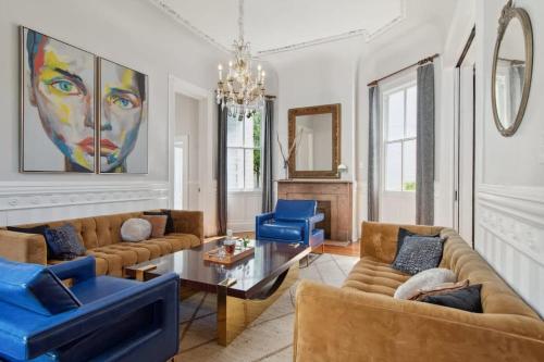 a living room with couches and a table and blue chairs at Opulent Expansive Unit Heated Pool and Spa in New Orleans