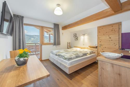 a bedroom with a bed and a table and a sink at Ferienbauernhof Wieserhof in Völs am Schlern