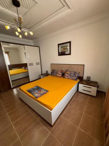 a bedroom with a large bed and a mirror at Villa Oasis Ain El Turk in Aïn El Turk