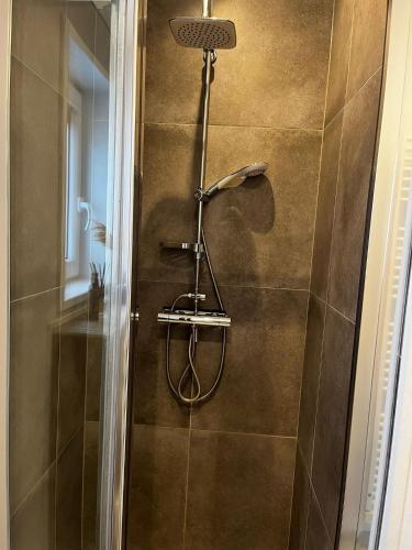 a shower with a shower head in a bathroom at Veluwe Retreat Inn Otterlo! in Otterlo