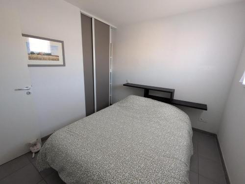 a small bedroom with a bed and a table at T2 Château vert in Le Grau-dʼAgde