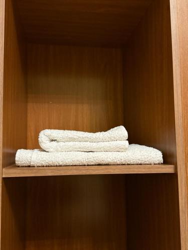two white towels sitting on a wooden shelf at Vintage Stile in Ganja