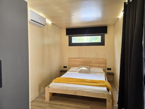 a small bedroom with a bed and a window at Camping Costa Dorada Tiny Amaia in Canet de Mar