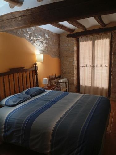 a bedroom with a large bed and a window at CASA VICENT in Valderrobres