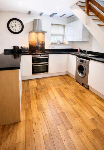 a kitchen with wooden floors and a clock on the wall at Chantry Place Morpeth House in Morpeth