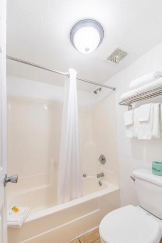 a white bathroom with a toilet and a shower at Seasons Florida Resort in Kissimmee