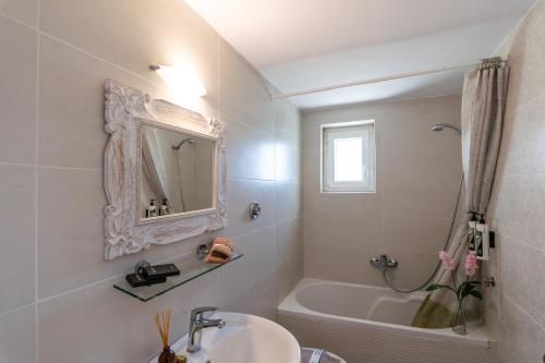 a bathroom with a sink and a tub and a mirror at Vira Señor House in Triovasálos