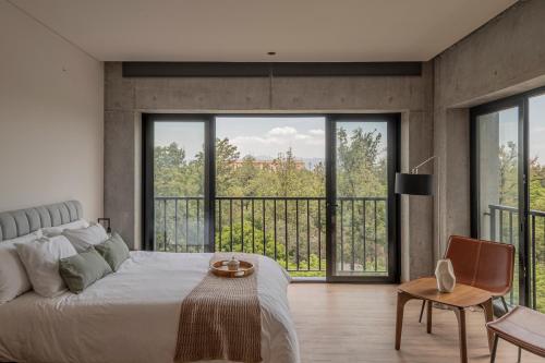 a bedroom with a bed and large windows at Second Home Juárez 56 in Mexico City