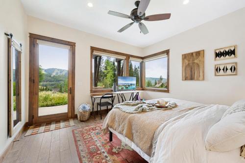 a bedroom with a bed and a desk and windows at Lakota Villa 607 Next to WP Resort I Private Hot Tub I Amazing Views I Activity Program in Winter Park