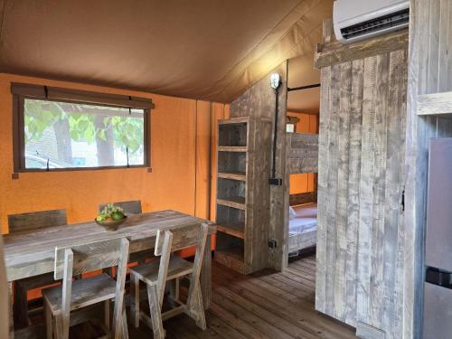 a dining room with a table and a bunk bed at Camping Costa Dorada Tienda Lua in Canet de Mar