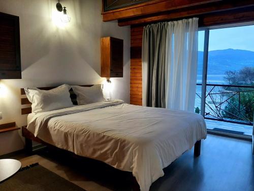 a bedroom with a bed and a large window at La Piticu in Dubova