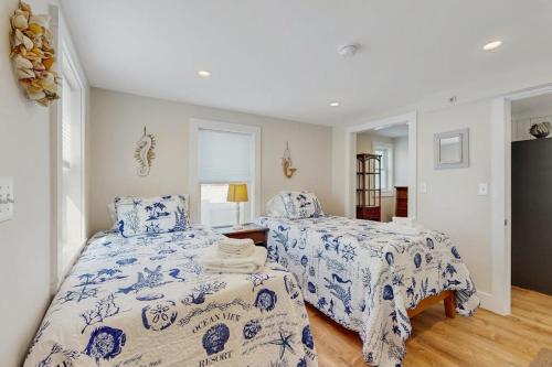 a bedroom with two beds with blue and white sheets at Cool Change in Hampton