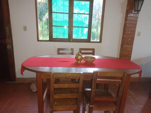 a table with chairs and a red table cloth on it at Villa Jucumarini in Coroico