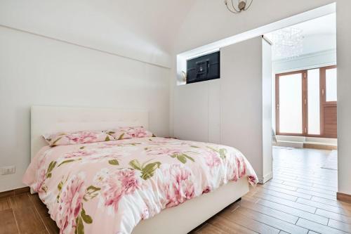 a bedroom with a pink bed with a tv on the wall at La casetta di pami- Enjoy Apulia in Monopoli