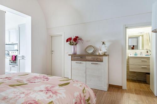 a bedroom with a bed and a bathroom with a sink at La casetta di pami- Enjoy Apulia in Monopoli