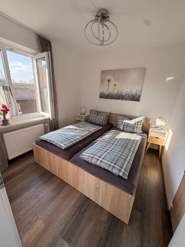 a bedroom with a large bed and a window at Apartments Reischl in Bergkirchen