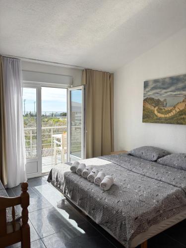 a bedroom with a large bed and a balcony at Villa Cherry in Bar