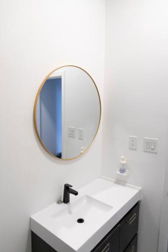 ein Badezimmer mit Waschbecken und Spiegel in der Unterkunft Check Inn in Toronto