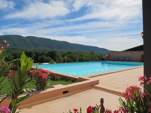 Blick auf einen Pool mit Bergen im Hintergrund in der Unterkunft Domaine de la Bastidonne in Céreste