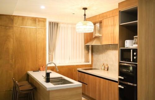 a kitchen with a sink and a black refrigerator at Radiance Stay in Paengnodam