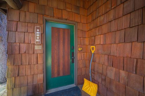 a wooden wall with a green door and an umbrella at 61 Wildflower in Sunriver