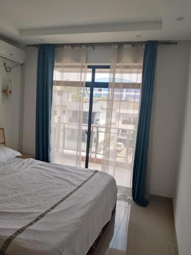 a bedroom with a bed and a large window at 海客瀛洲 Haïke-Îlezone in Abidjan