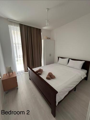 a bedroom with a large bed with two towels on it at Luna duplex Apartment in Star Dojran